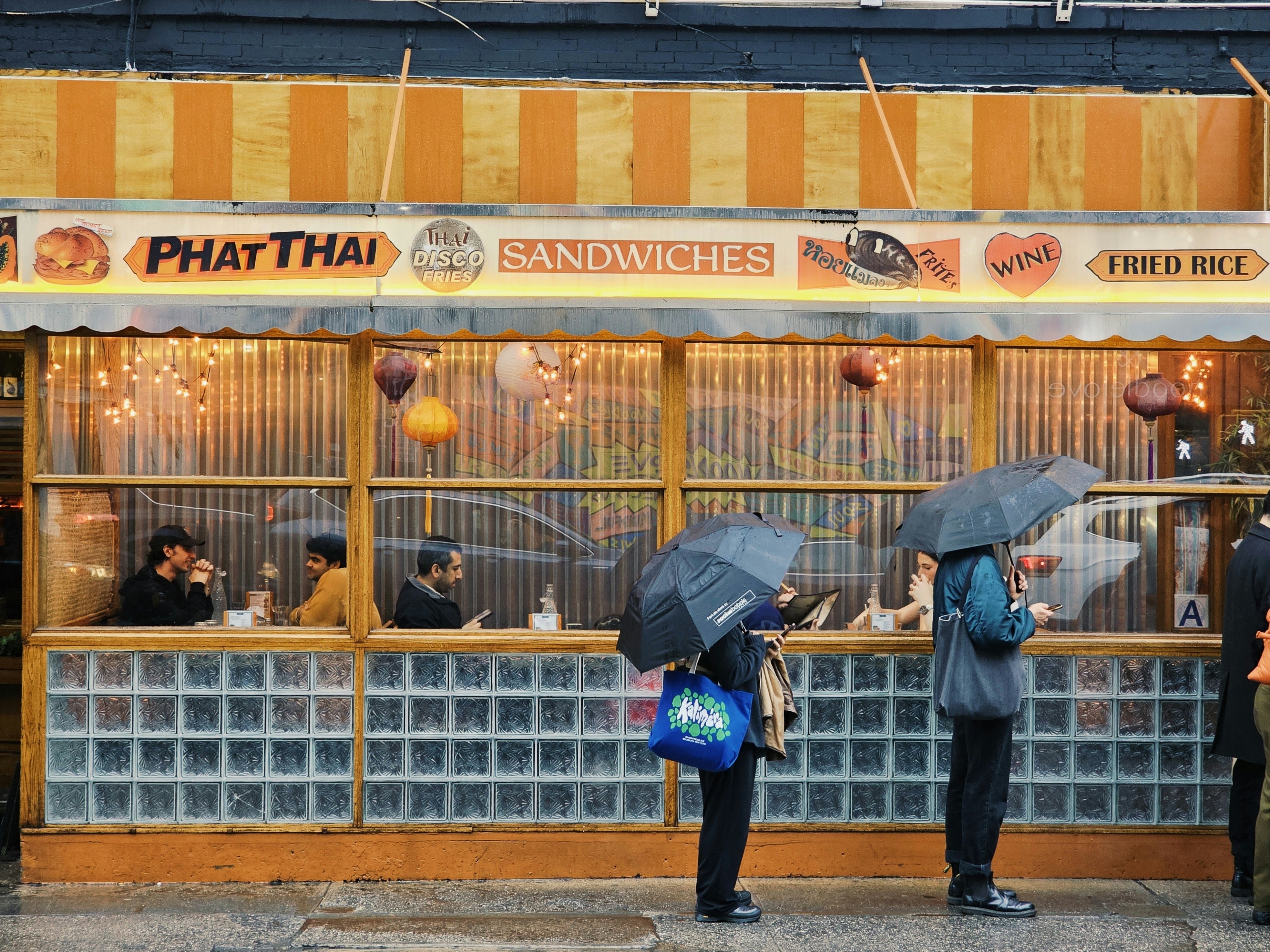 a group of people standing outside of a restaurant